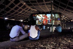 Cinemagoers watch a Bollywood film inside a tent cinema in Pusegaon